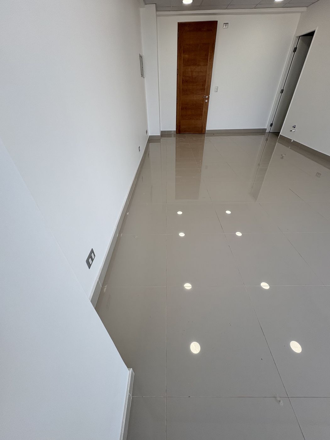 Oficina habilitada con porcelanato pulido y puerta de madera, lista para operar
